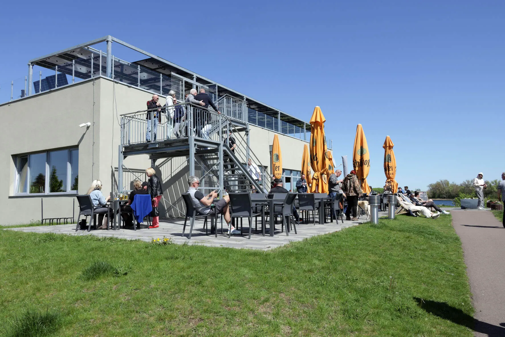 Sonnige Terrasse des HuGo mit Sonnenschirmen und Dachterrasse